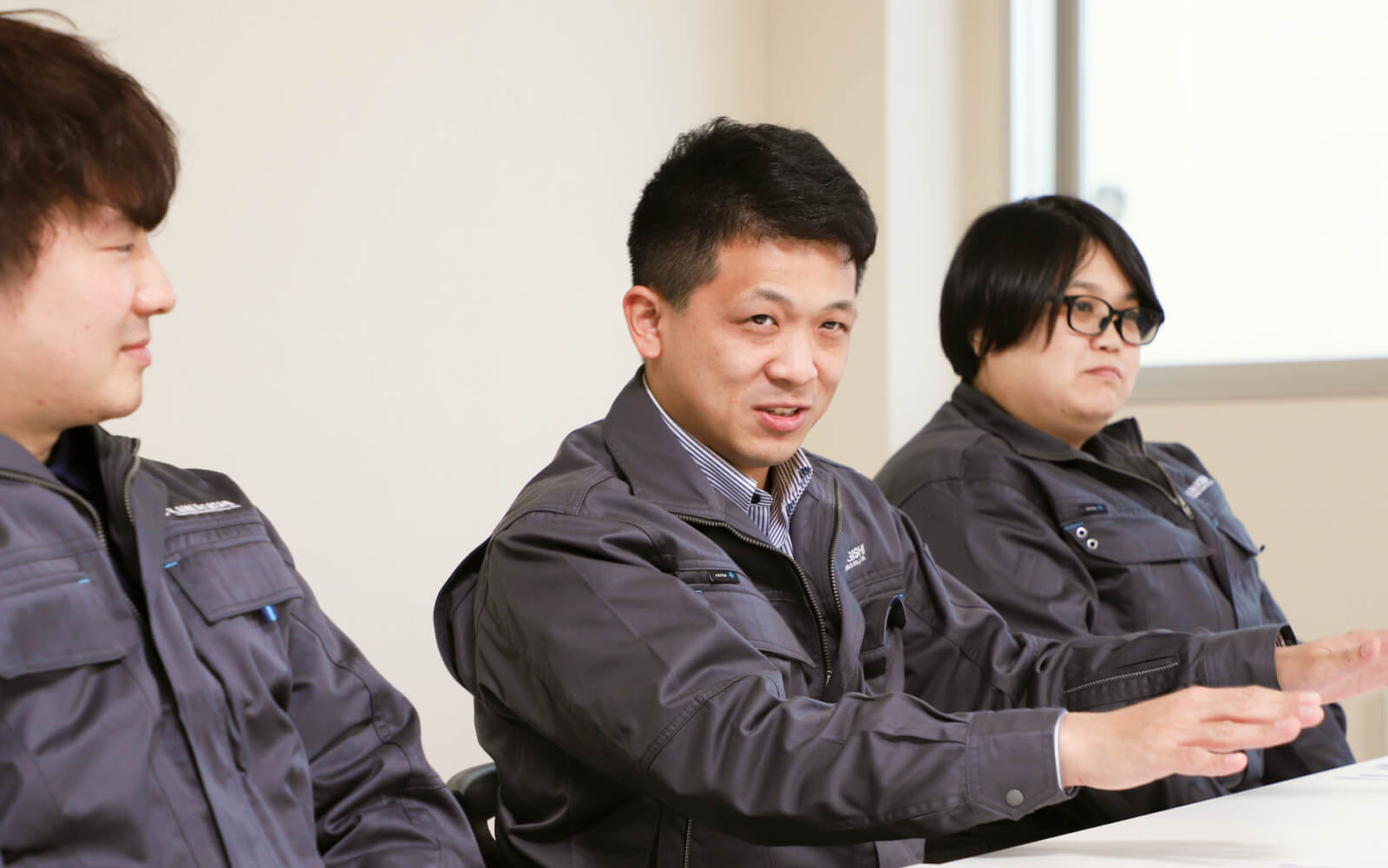 座談会の様子。山本が身振りを交えて発言し、他の参加者が耳を傾けている