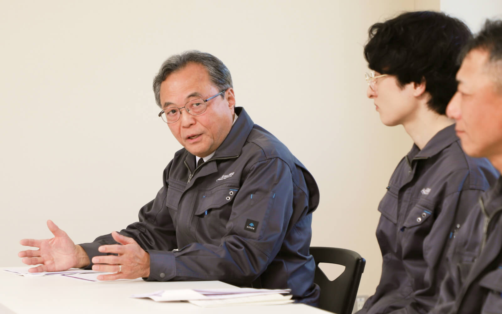 座談会の様子。清時社長が身振りを交えながら語り、社員が聞き入っている